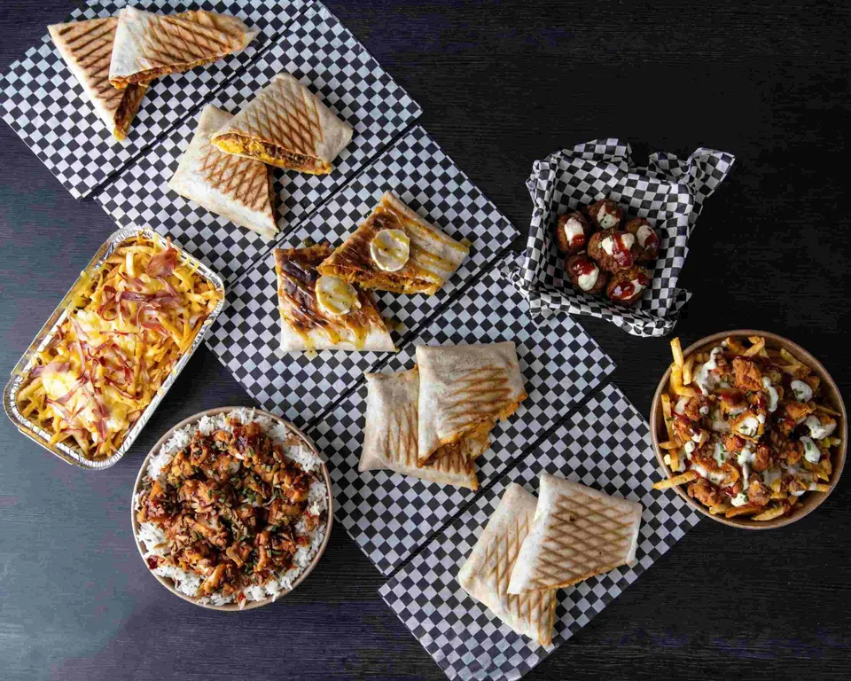 La carta al completo sobre papel de cuadros: french tacos, bowls, patatas y entrantes vistos desde arriba