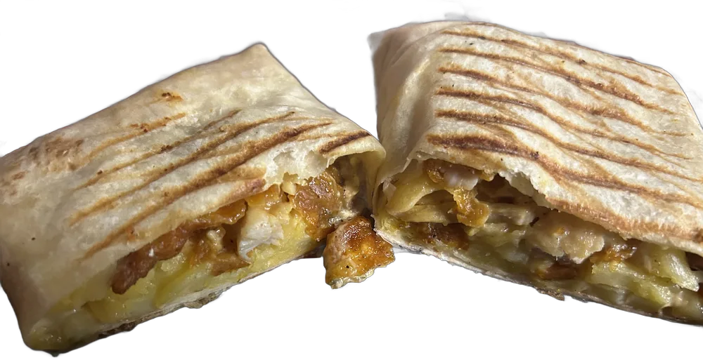 French taco a la plancha partido en dos mitades, con el relleno de pollo y queso fundido a la vista